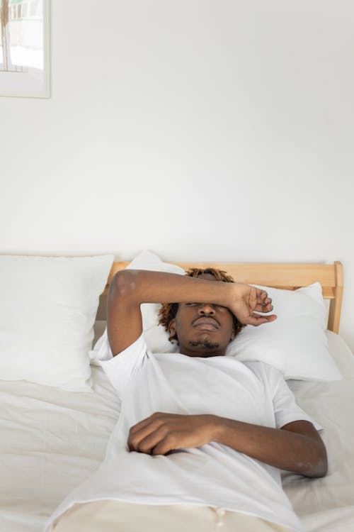 A Man in White Shirt Sleeping on the Bed