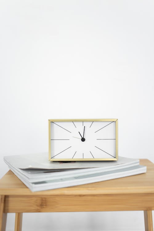 Free An Analog Clock on a Wooden table Stock Photo