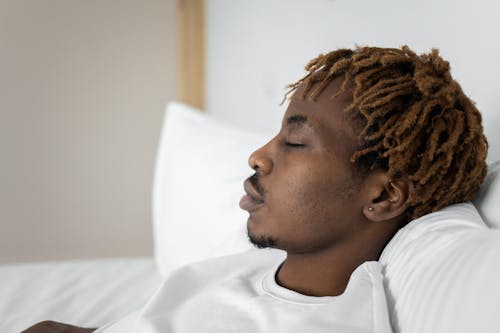 Free Close-Up Shot of a Man in White Shirt Resting on the Bed Stock Photo