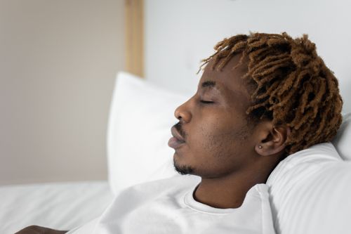 Free Close-up of a young man sleeping in bed, capturing a serene moment of rest and relaxation. Stock Photo