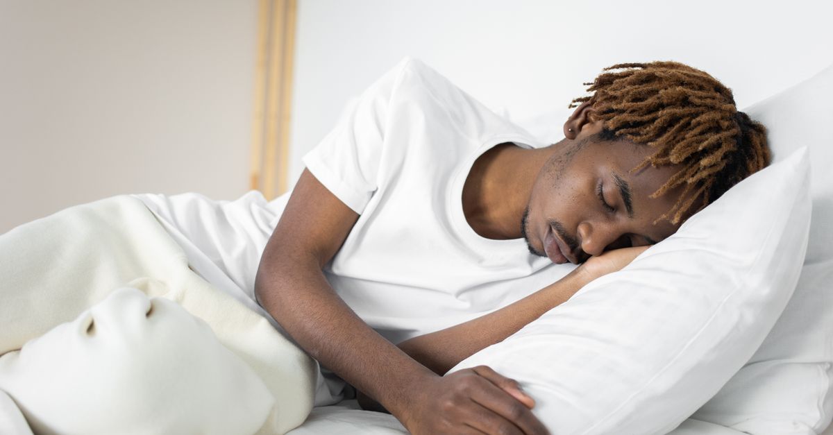 A serene image of a man sleeping peacefully on a white pillow and blanket indoors. - Evidence evidence guide for magnesium sleep quality meta-analysis