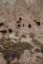 Ancient high rocky formations with carved holes located on grassy ground in old famous national park of Cappadocia in Turkey