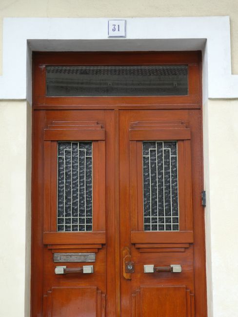 Ornate wooden double doors with stained glass panels and transom window.