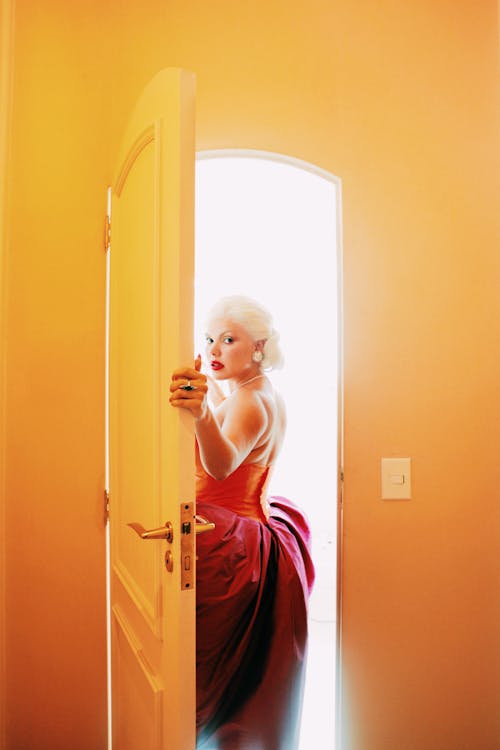 
A Woman in a Backless Dress Going Outside a Room