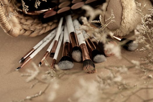 A collection of makeup brushes arranged artistically with natural elements in soft light.