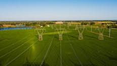 Endless meadow with fresh green grass and power station