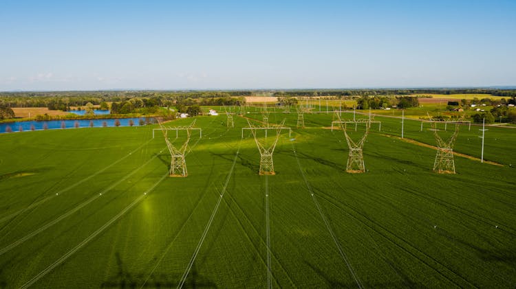 Endless Meadow With Fresh Green Grass And Power Station