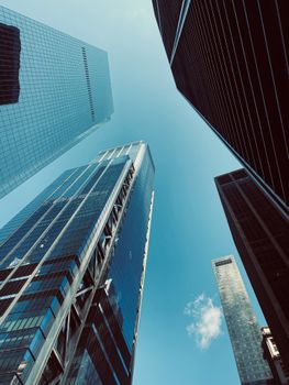 A stunning low-angle shot of skyscrapers reaching into a clear blue sky, capturing urban architectural beauty.
