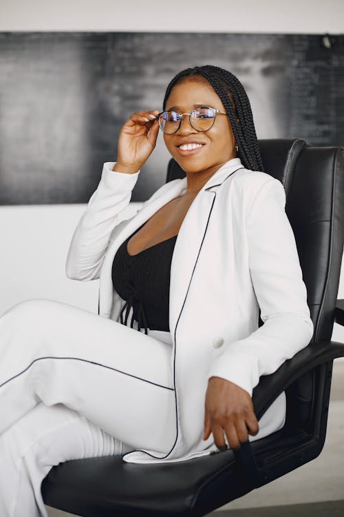 A Woman in a White Blazer and Sitting on an Office Chair