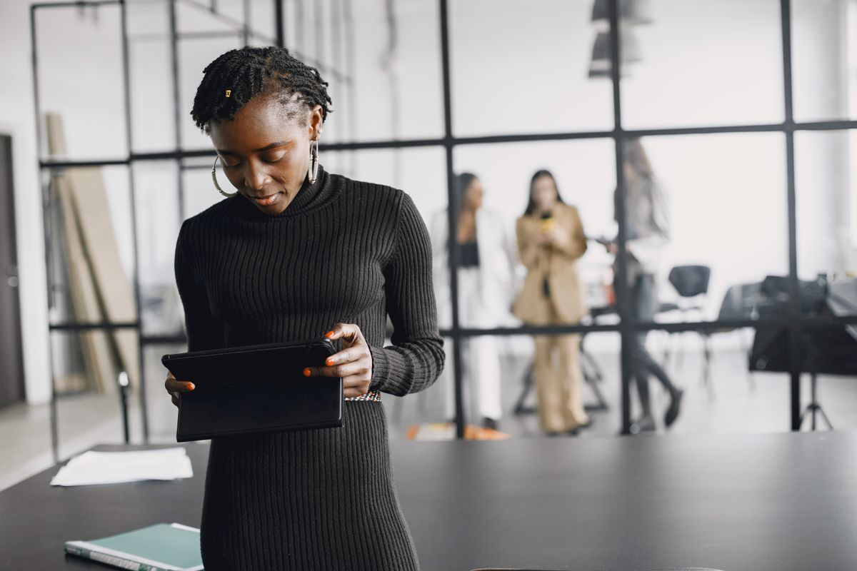 A business professional using a digital tablet in a modern office