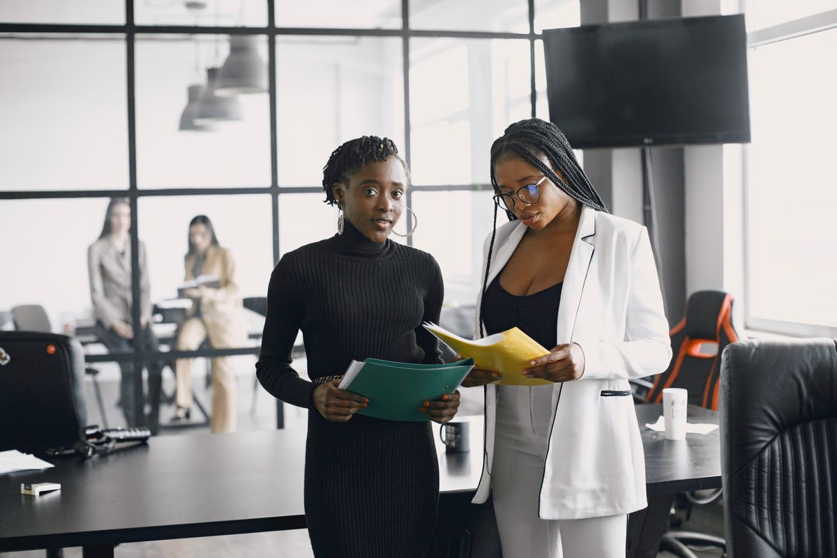 Black businesswomen reviewing documents in a modern office