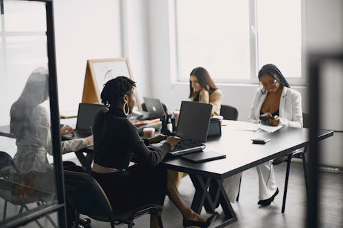 Free Women Sitting at the Office Table Stock Photo