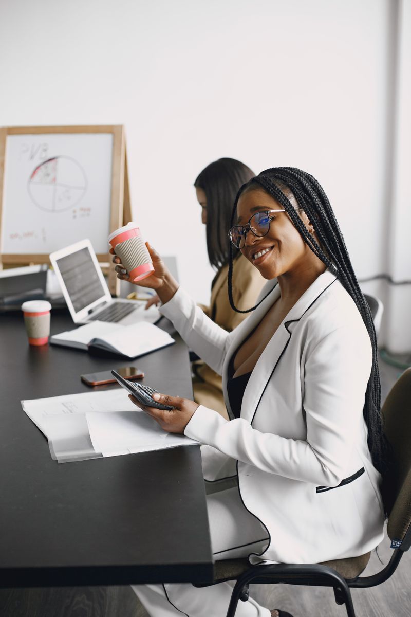 Woman in a white blazer holding a cup