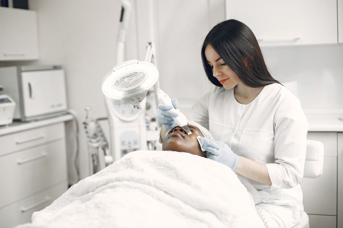 Practitioner performing a HydraFacial treatment in a modern clinic