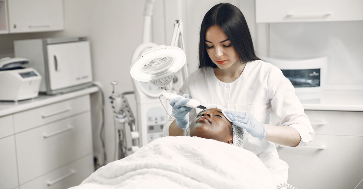 Microneedling behandling – estetiker utför professionell ansiktsbehandling på klinik