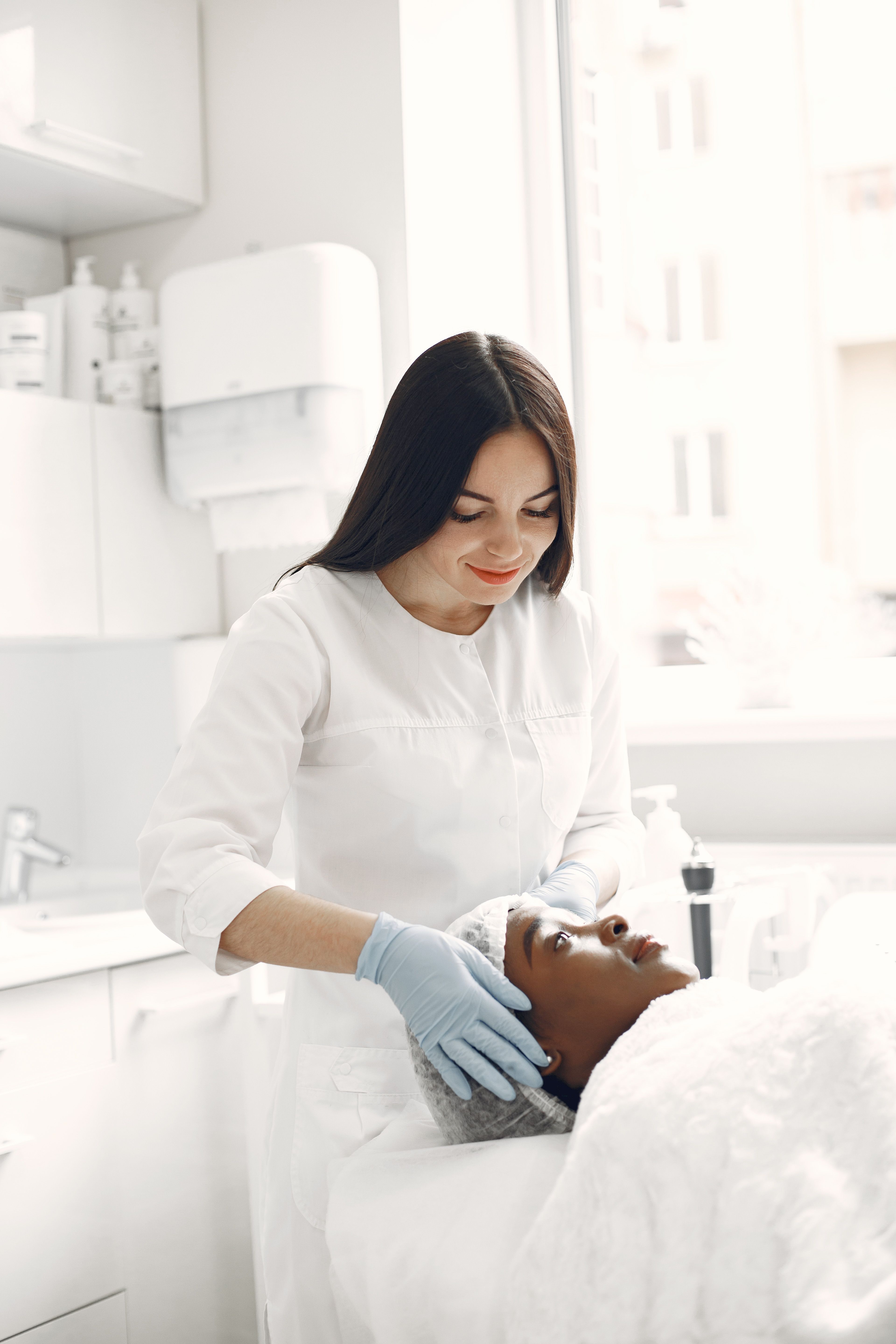 Beautician carrying out a facial for a relaxed client