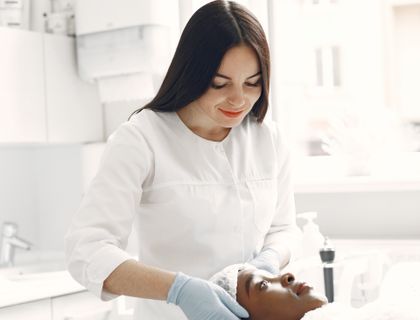 Beautician carrying out a facial for a relaxed client