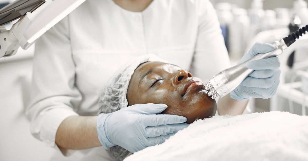 A dermatologist performing a laser treatment on a relaxed client in a clinic. - Evidence evidence guide for collagen dermal health randomized trial