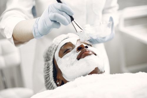 Free A relaxing facial treatment with a face mask applied by a professional in a spa. Stock Photo