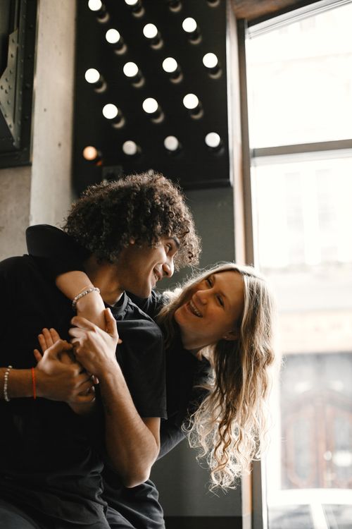 Free Happy couple enjoying a playful embrace indoors, radiating love and affection. Stock Photo
