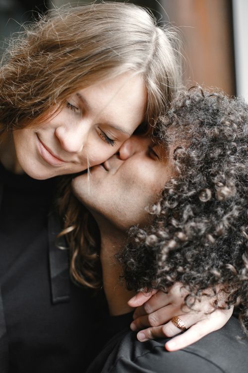 Free Close-up of a loving couple sharing an intimate kiss indoors. Stock Photo