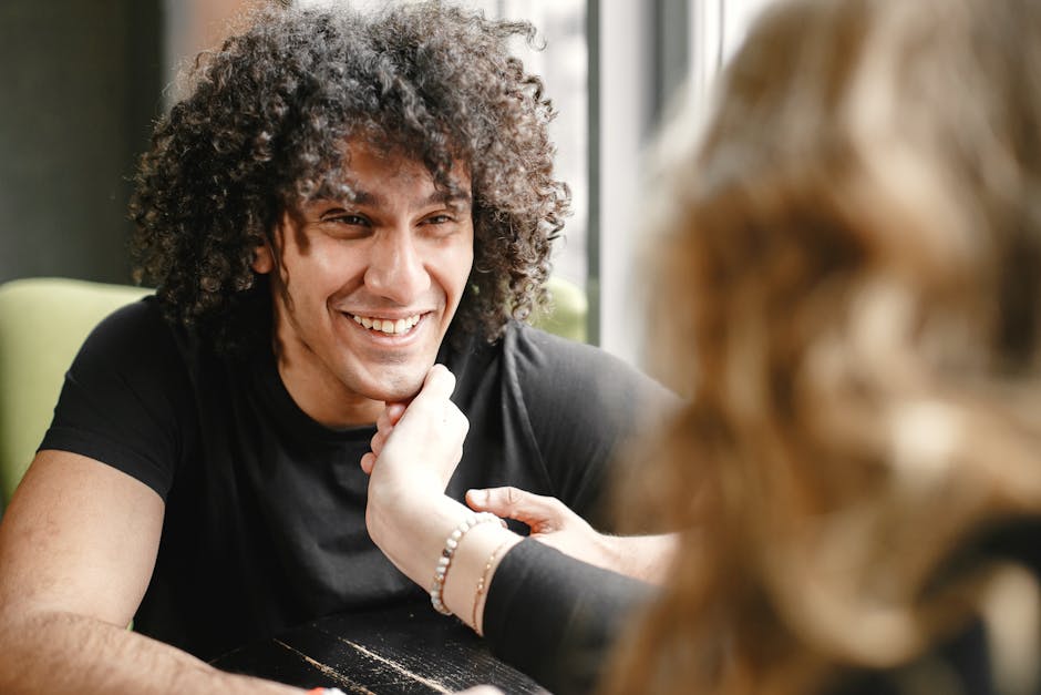 Cuplu într-un moment de intimitate la cafenea, comunicând prin atingere