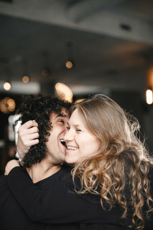 Free A happy couple embracing and laughing indoors, showcasing affection and love. Stock Photo