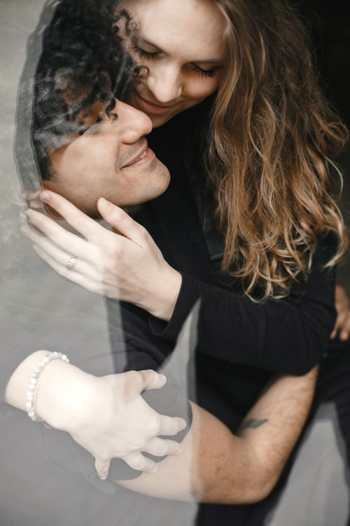 Free Happy couple embracing, sharing affectionate smiles inside. A warm, romantic moment captured with love. Stock Photo