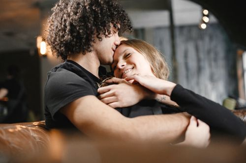 Free A joyful couple embracing and sharing a tender moment indoors, evoking warmth and love. Stock Photo