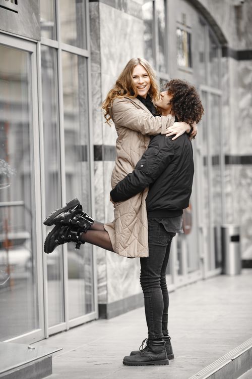 Free A couple shares a joyful embrace outdoors in an urban setting, capturing love and connection. Stock Photo