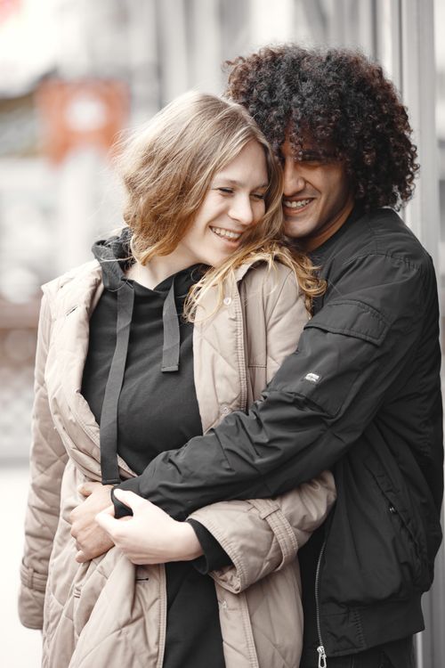 Free Happy couple in jackets embracing outdoors, exuding warmth and joy on a cool day. Stock Photo