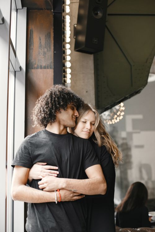 Free A couple embraces warmly in a stylish urban café, showcasing love and togetherness. Stock Photo