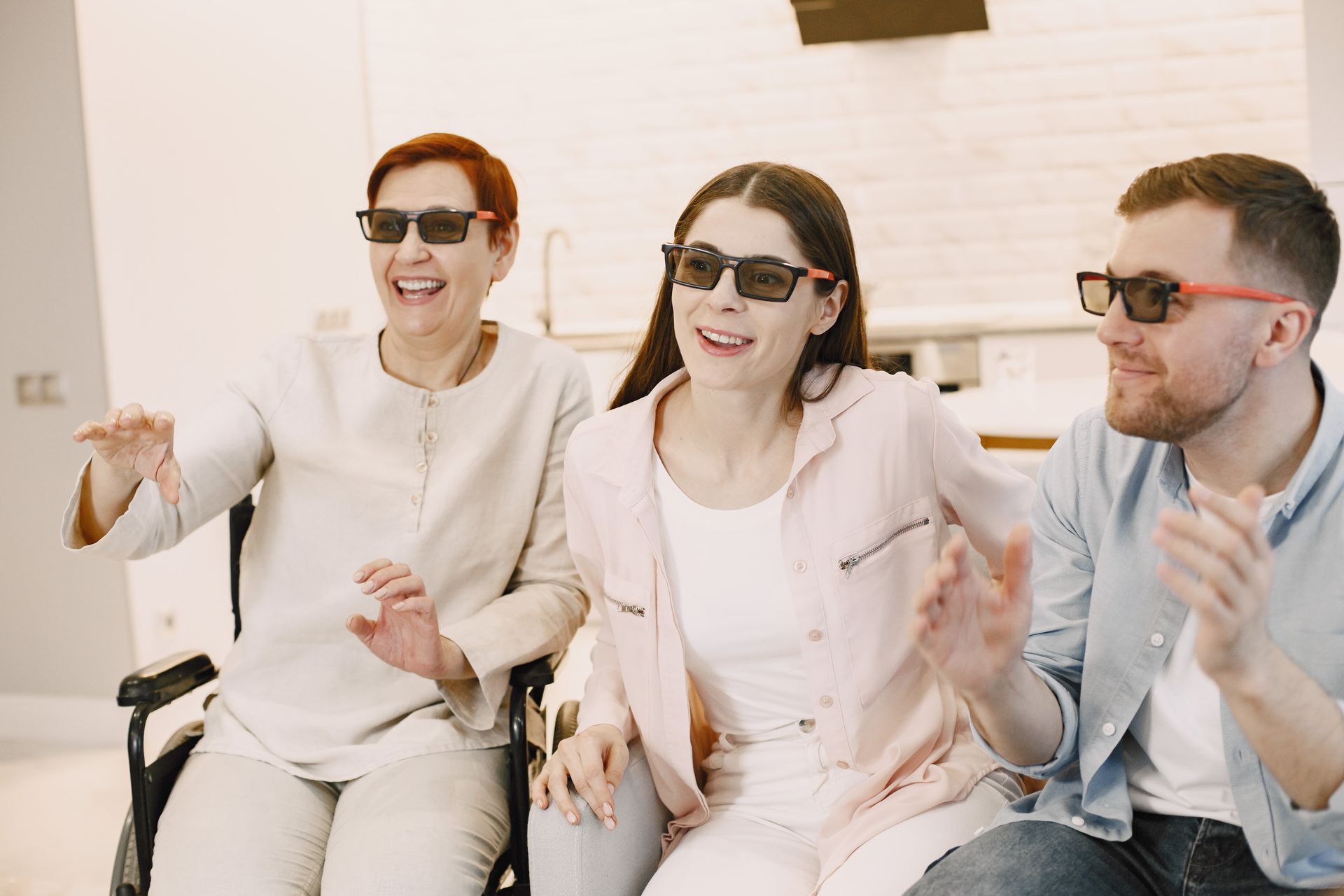 Three adults enjoying 3D movie at home, showcasing family fun and happiness.