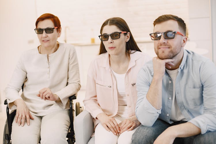 Woman And Her Adult Children Watching A Movie In 3D Glasses At Home 