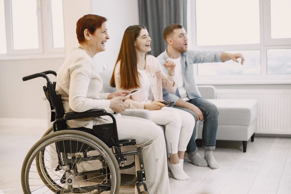 Spokojná seniorka na invalidnom vozíku trávi čas so svojou rodinou doma