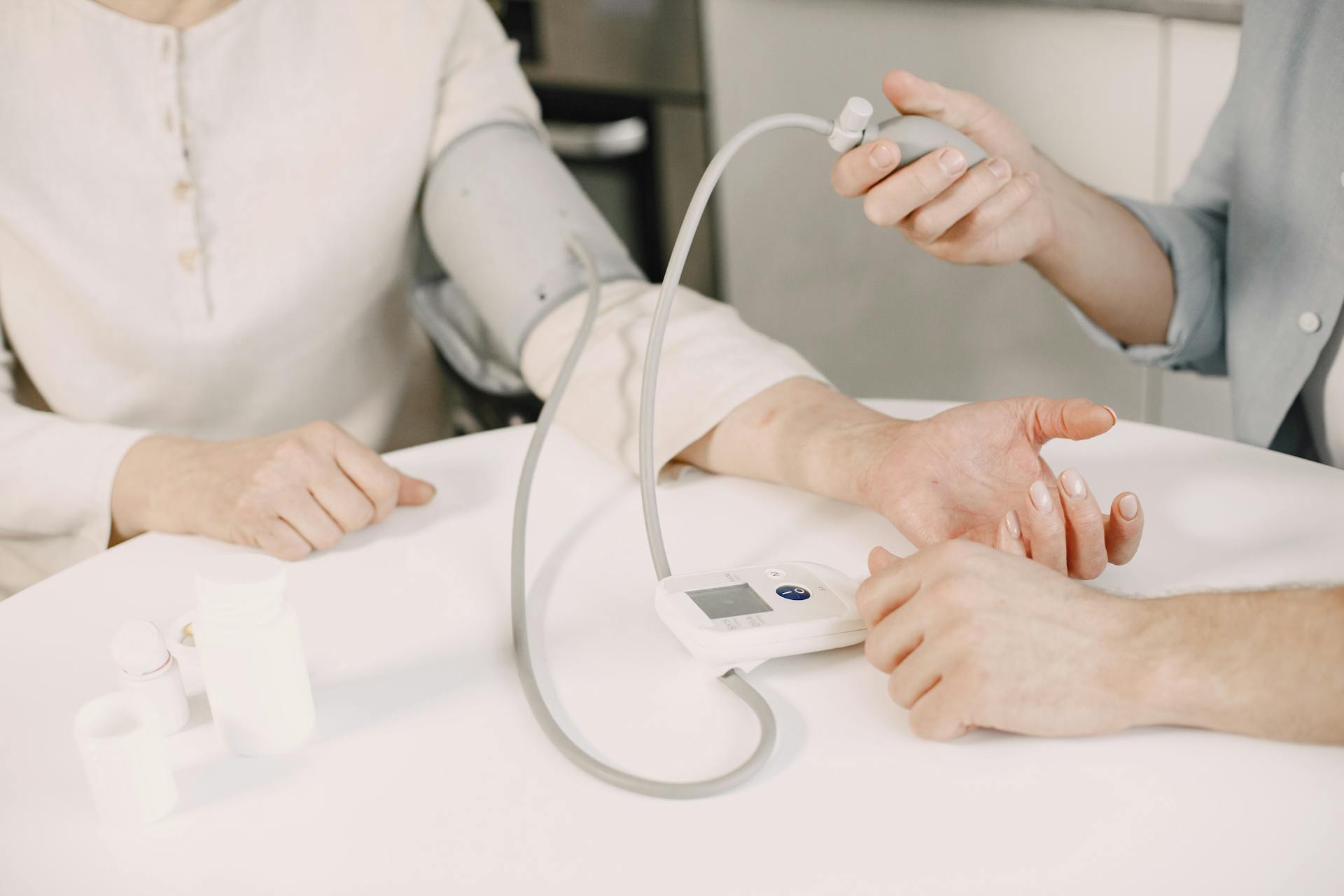 Close-up of blood pressure measurement at home highlighting healthcare equipment.