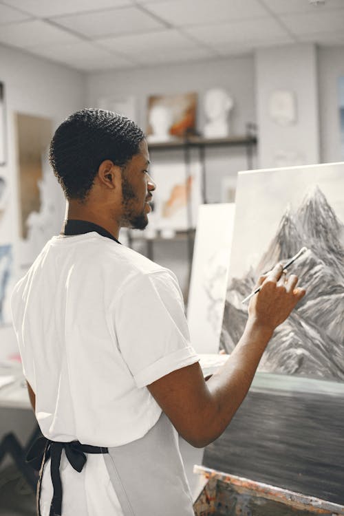 A Man Drawing Mountain on a Canvas
