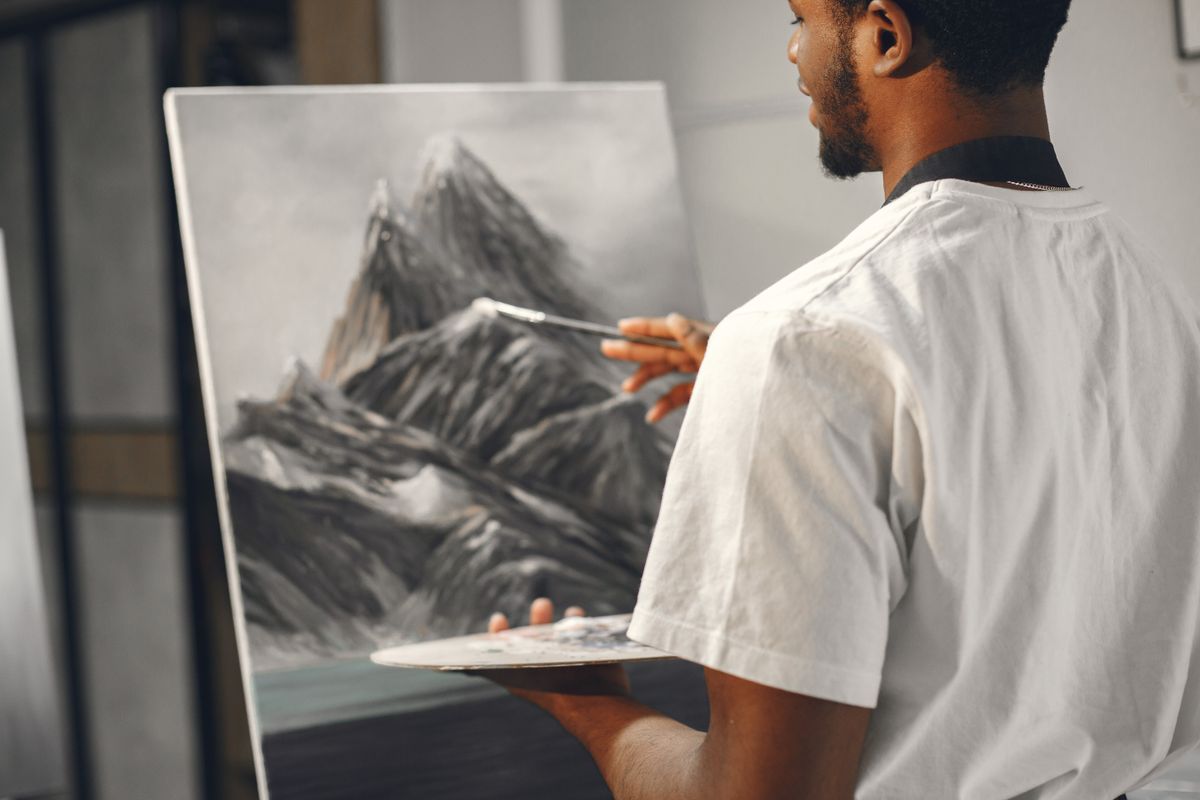 An artist painting a mountain landscape on canvas