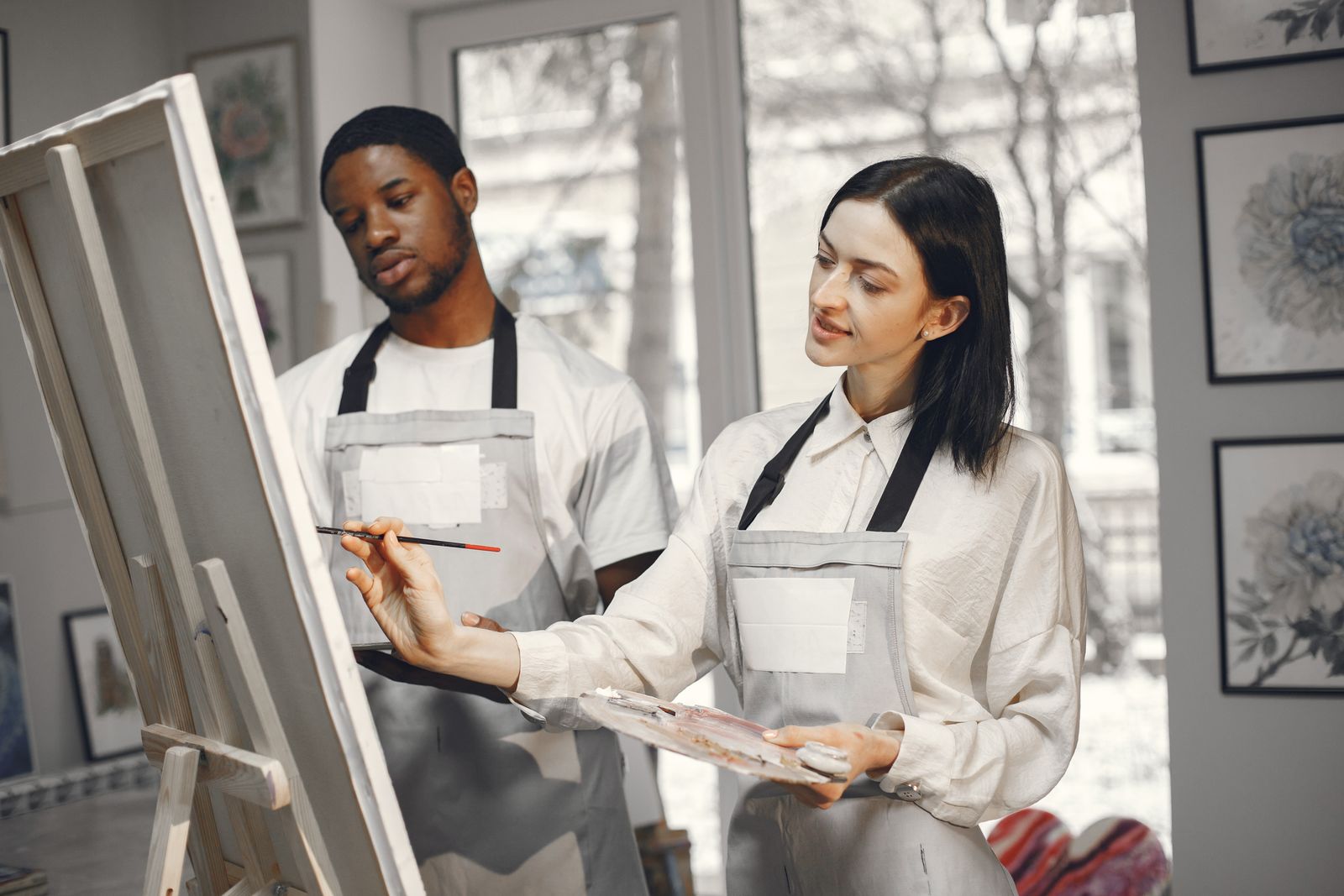 Two people painting together at an easel
