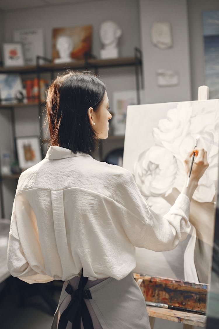 Back View Of A Woman Painting On Canvas