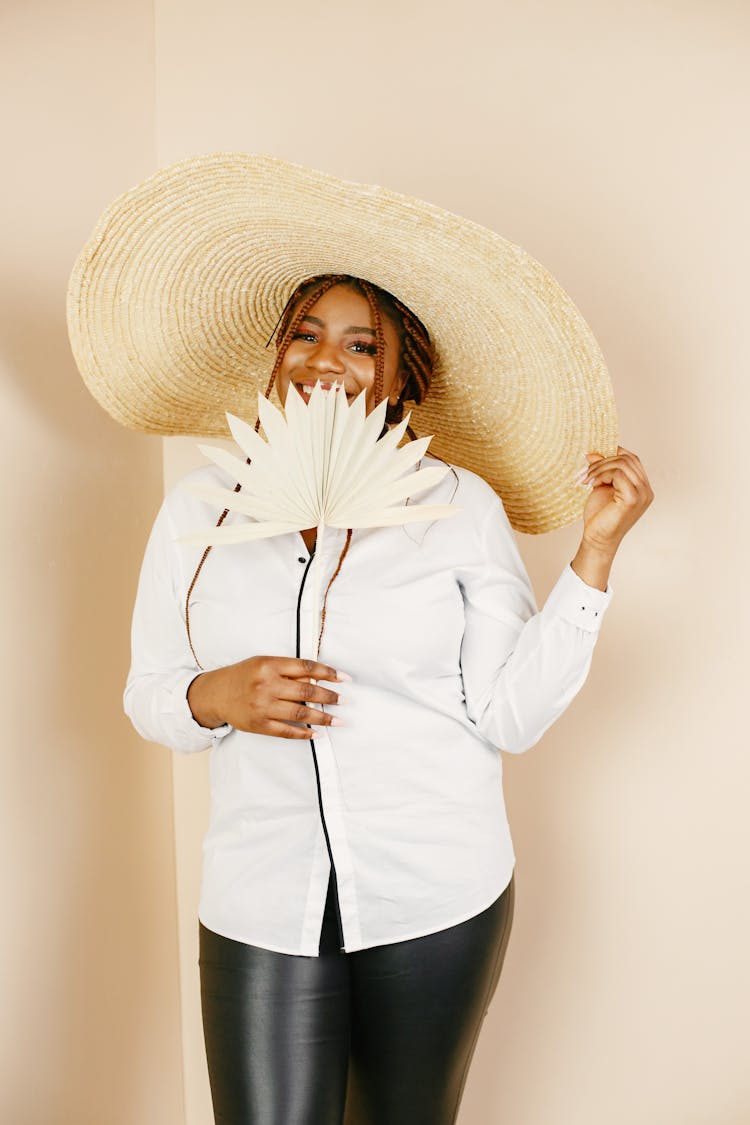 Woman In White Shirt And Hat Holding Paper Fan 