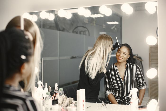 Maquillage professionnel d'une artiste dans un espace backstage lumineux