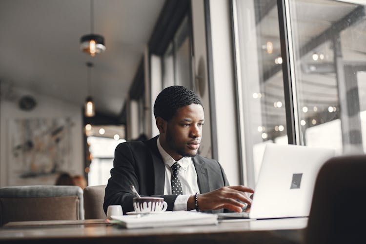 Businessman Working On Laptop In Cafe