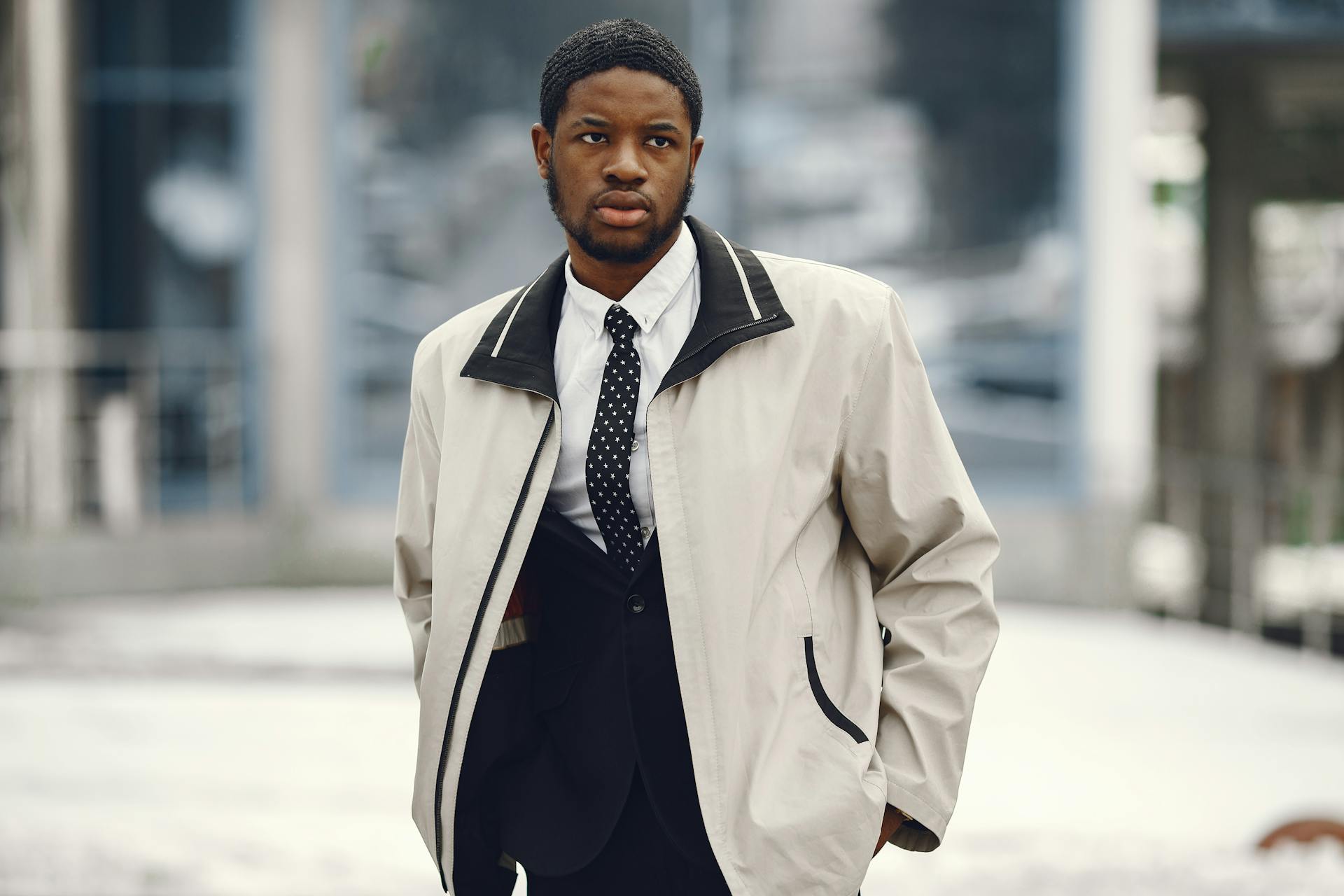 Portrait of a confident African American businessman in a white jacket and tie, outdoors.