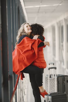 A joyful reunion of a happy couple embracing with travel luggage in an airport.