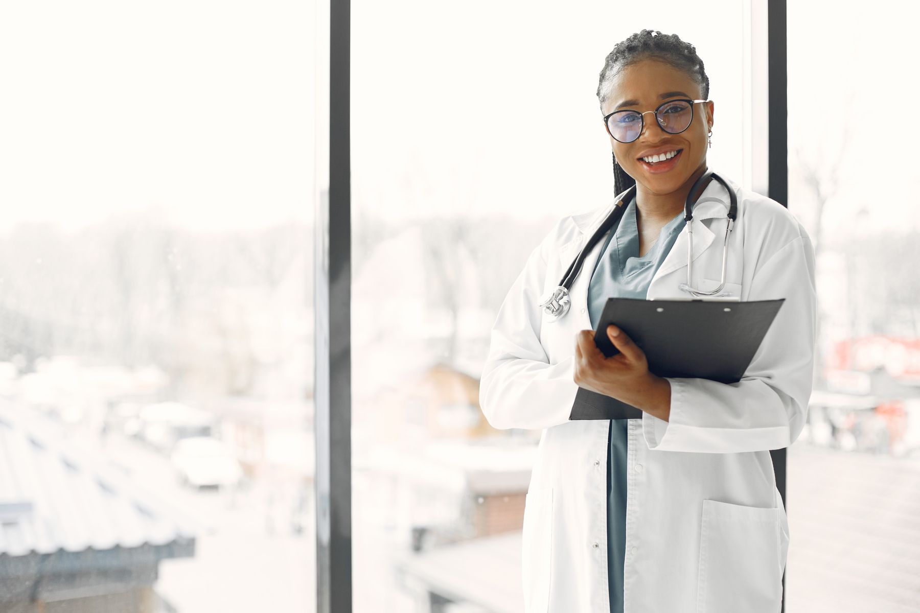 Smiling female doctor holding a clipboard in a bright clinic