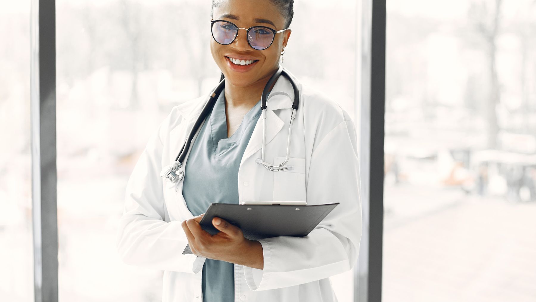 Smiling female healthcare professional with clipboard in a bright modern clinic