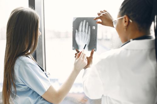 Free Two doctors examine a hand X-ray in a hospital setting. Stock Photo