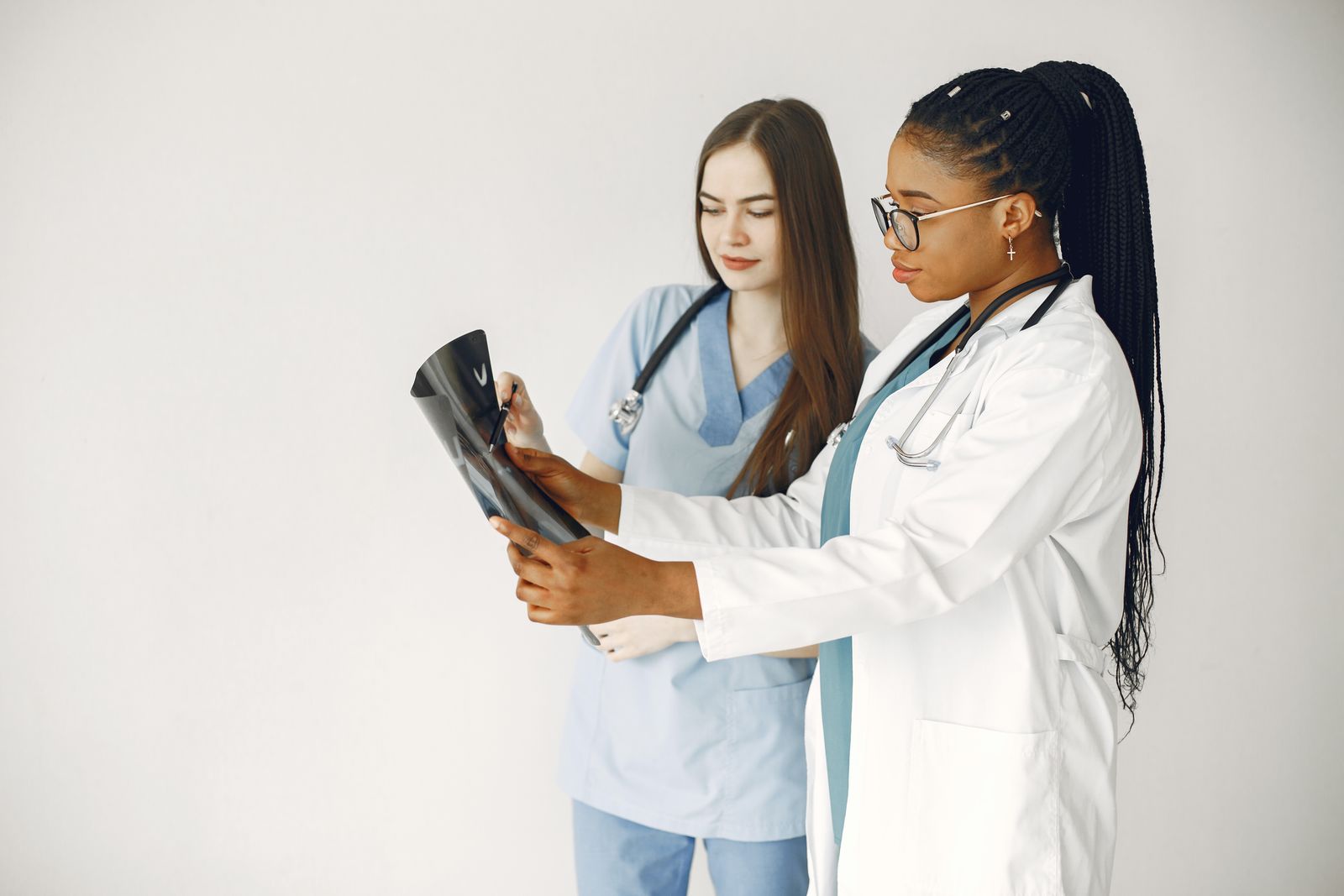 Two clinicians reviewing an imaging film together — photo by Gustavo Fring on Pexels