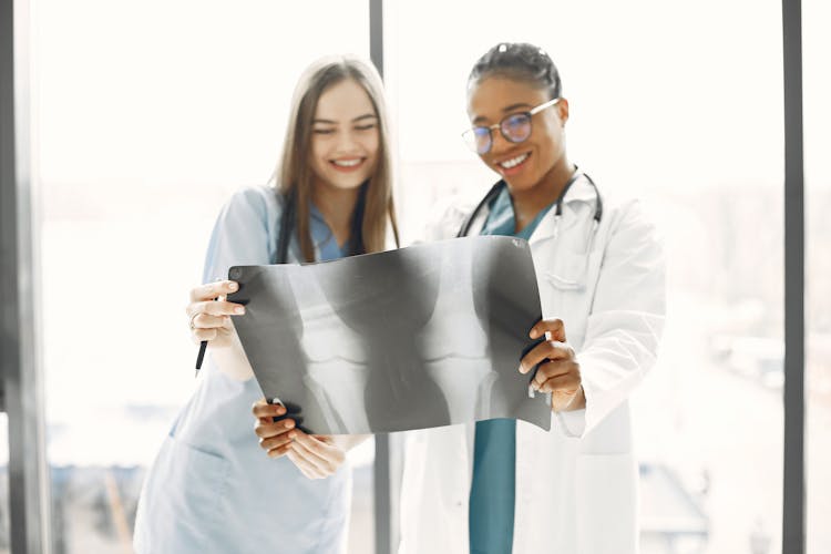 Doctor And Nurse Looking At An X-ray Picture And Smiling 